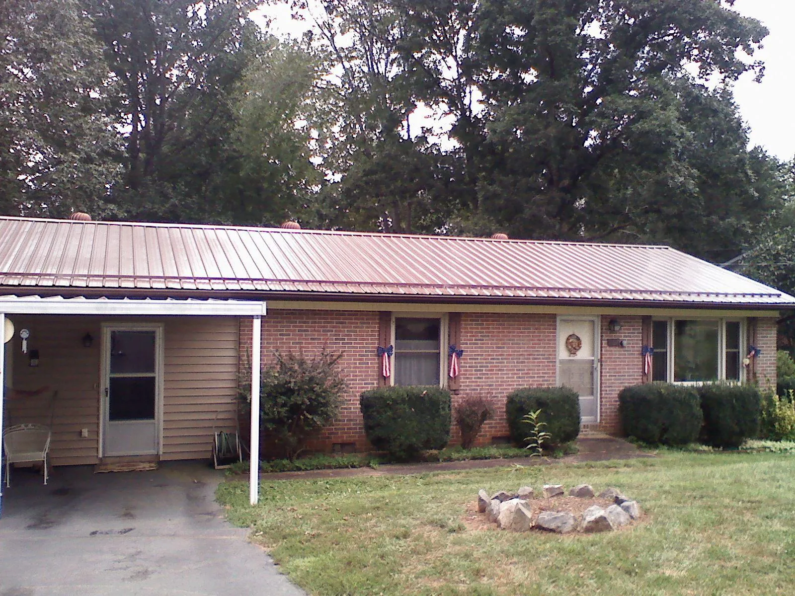 Bronze metal roof and carport on a brick ranch home — Roof Repair work by our crew in Jacksboro